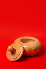 Wooden sugar bowl on a red background