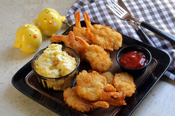 Breaded shrimp with potato salad, and cocktail sauce for dipping