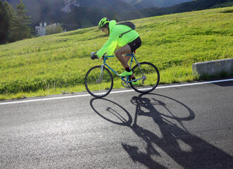 Fototapeta premium young cyclist with racing bicycle and phosphorescent waterproof jacket on the road