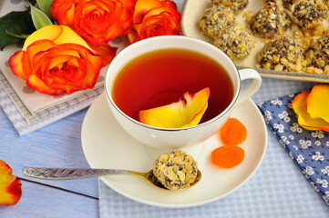 A white cup of tea and sweets on the table.