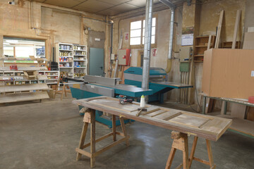 view of a corner of a carpentry with a machine and a door that is being repaired