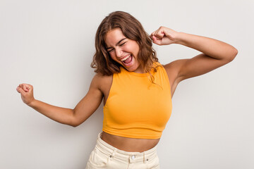 Young caucasian woman isolated on blue background dancing and having fun.