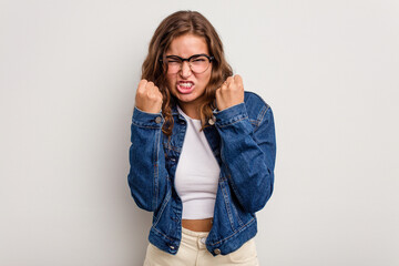Young caucasian woman isolated on blue background upset screaming with tense hands.