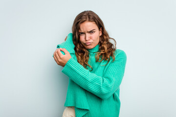 Young caucasian woman isolated on blue background having a neck pain due to stress, massaging and touching it with hand.