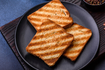 Traditional English breakfast with eggs, toast, sausages, beans, spices and herbs on a grey ceramic plate