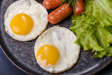 Traditional English breakfast with eggs, toast, sausages, beans, spices and herbs on a grey ceramic plate