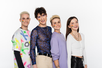 Obraz premium smiling lgbtq community friends with rainbow flags on faces looking at camera isolated on grey.