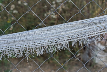 gray metal mesh with a strip of white fabric on the street