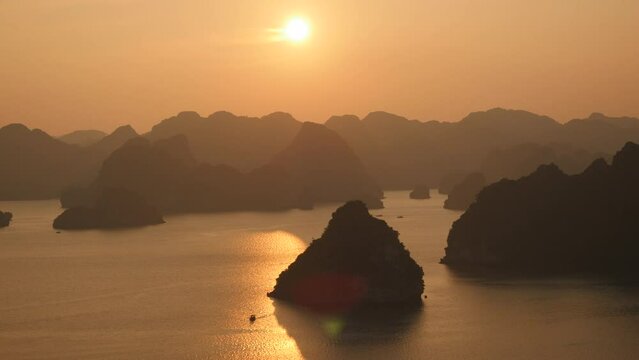 Tilt up shot showing dramatic karst scenery at sunset at Halong Bay, northern Vietnam. 