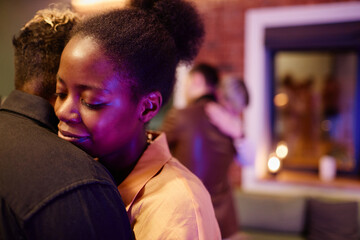 Happy young woman standing close to her girlfriend during romantic slow dance against amorous gay couple embracing one another - obrazy, fototapety, plakaty