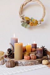 Autumn table decoration. Interior decor for fall holidays with handmade pumpkins and candles. Holiday greeting card