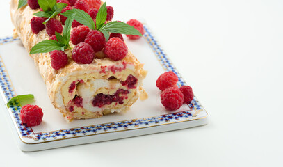 Baked meringue roll with cream and fresh red raspberry, white background