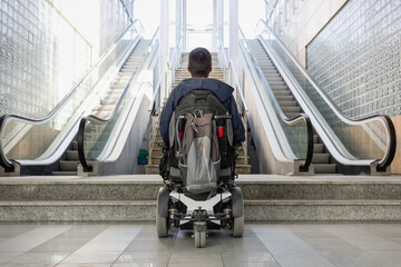 Man with disability on wheelchair stopped in front of staircase, raising awareness of architectural barriers and accessibility issues - obrazy, fototapety, plakaty