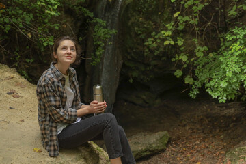 girl in the forest with a thermos