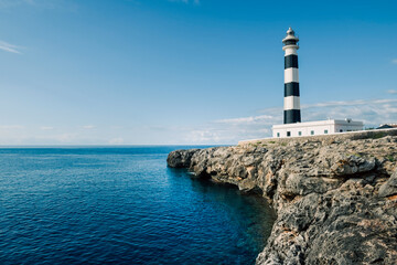 Beautiful clear ocean water with striking coastal feature of a lighthouse on the cliff