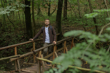 Fototapeta premium a young man is walking near the road and in the forest