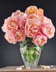 A bouquet of beautiful peach pink Marie Curie roses on the wooden table