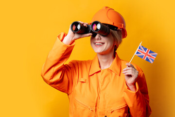 woman worker in helmet and overalls with binoculars and GB flag