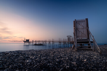 il tramonto sul trabocco di punta aderci, a vasto. il sole cala nell'entroterra abruzzese, dietro...