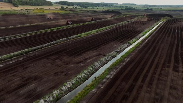 Peat Harvester Tractor on Collecting Extracting Peat. Mining and harvesting peatland. Area drained of the mire are used for peat extraction. Drainage and destruction of peat bogs. 