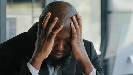 Sick exhausted african man suffer from headache migraine syndrome hold head by hands tired...