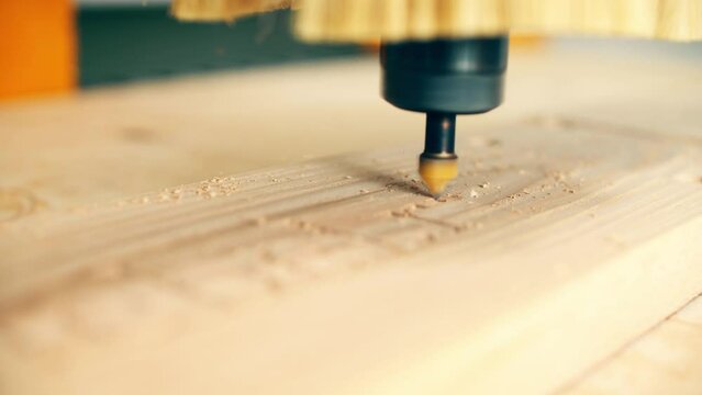 Modern CNC router bit engraves wood, close up shot