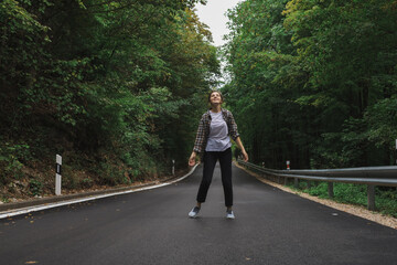 beautiful girl walks in the forest near the road