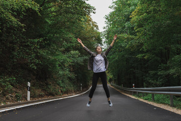 beautiful girl walks in the forest near the road