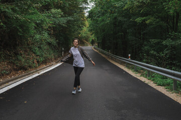 Obraz premium beautiful girl walks in the forest near the road