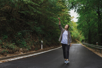 beautiful girl walks in the forest near the road