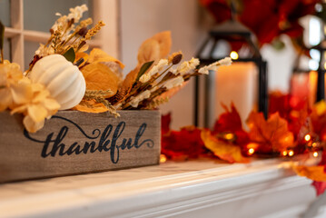 Fall holiday mantel decorated with colorful leaves and twinkle lights - 530181526