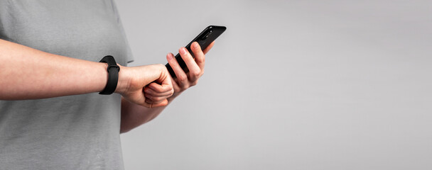 Banner with woman looking at fitness tracker app at phone and checking sports results, health metrics. Healthy lifestyle concept. Female holding smartphone. Copy space