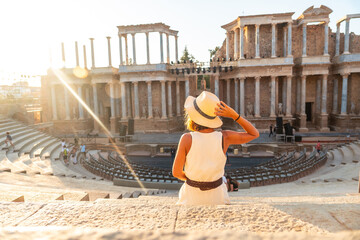 Roman Ruins of Merida, a young tourist in a white dress visiting the Roman Theater. Extremadura,...