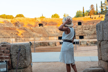 Fototapeta premium Roman Ruins of Merida, a young woman visiting the Roman Amphitheater from inside. Extremadura, Spain