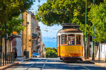Famous yellow vintage tram in the street of Alfama, Lisbon, Portugal - obrazy, fototapety, plakaty