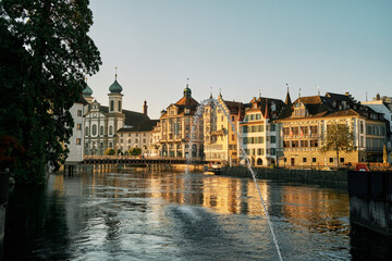 Fototapeta na wymiar Water jet flowing into river at sunset in Lucerne