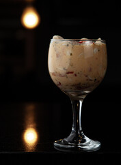 Copa llena de ceviche en fondo negro 