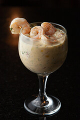 Copa llena de ceviche de camarones en fondo negro 