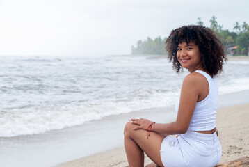 Fototapeta na wymiar Happy smiling young woman in the beach during summer vacation