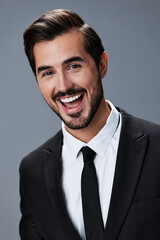 Portrait of a business man with a natural smile with teeth on a gray background in a business suit. Business portrait of a stylish man copy space