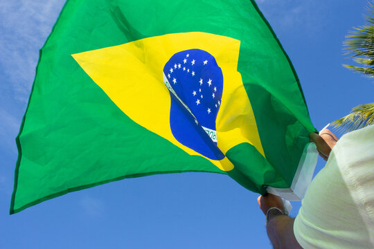 man holding brazil flag in his hands
