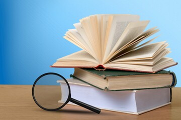 Open book with magnifying glass on stack book.  Concept for education.