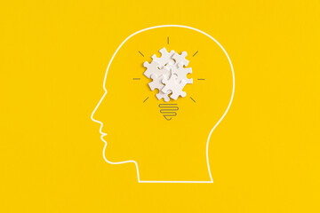 Human head with lightbulb on yellow background