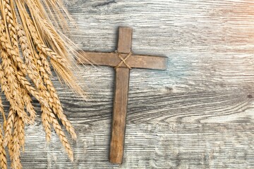 Wood cross with wheat on a wood desk