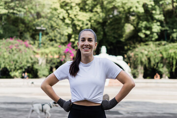 Fitness woman smiling, posing and looking at camera in a park.