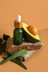 Composition with bottle of essential oil, aloe leaves and avocado on color background