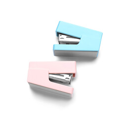 Two colorful staplers on white background