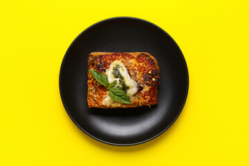 Plate with piece of tasty Italian pie on yellow background