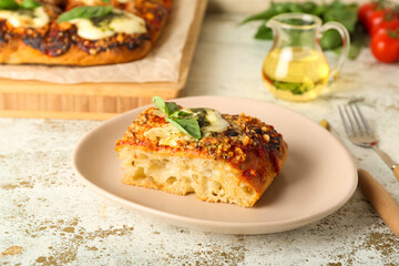 Plate with piece of delicious Italian pie on light background