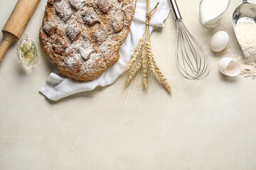 Fresh bread and ingredients for baking on light background